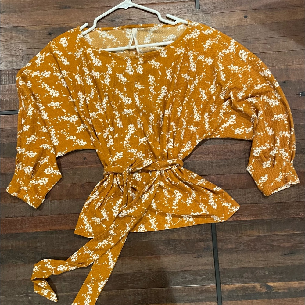 Anthropologie Amber Dolman copper orange colored blouse with a floral pattern.